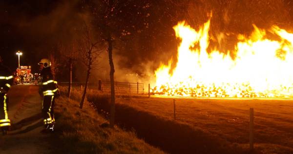 Grote stapel boomstammen in brand in Wijk en Aalburg .