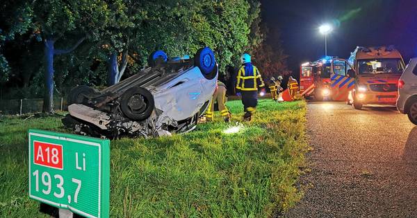 Auto over de kop op A18, passagier zwaargewond in auto achtergelaten - De Gelderlander
