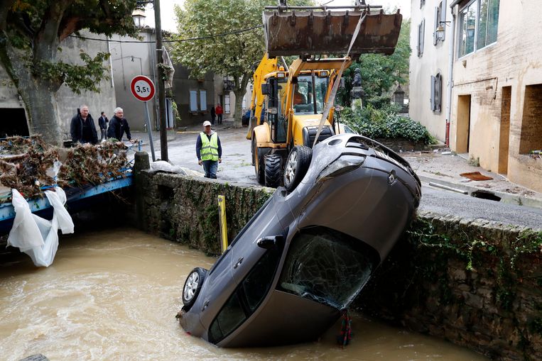 Met een sjofel wordt een auto uit het water getrokken in het dorp Villegailhenc Beeld EPA