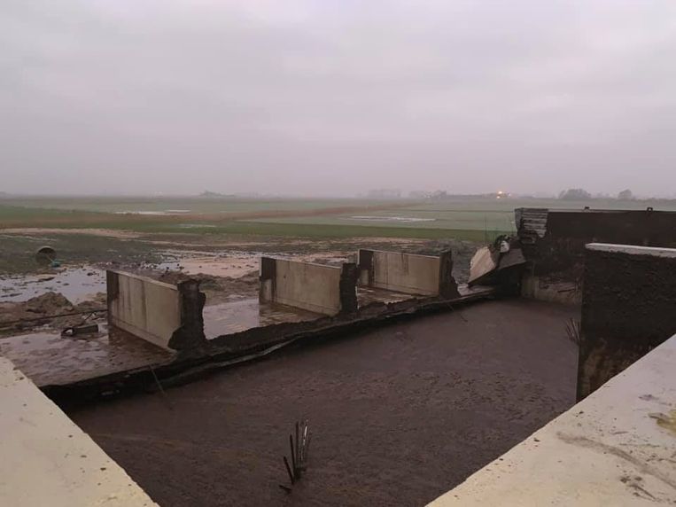 Op de foto is te zien hoe de betonnen muur volledig weg brak. De mest stroomde in de weilanden en akkers rondom het landbouwbedrijf.
