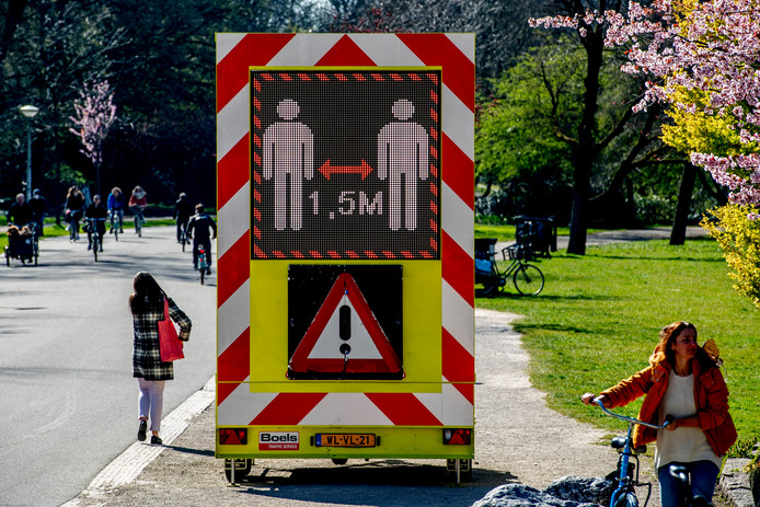 Een bord waarschuwt in het Vondelpark om 1,5 meter afstand te houden van elkaar vanwege het coronavirus.