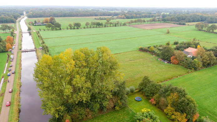 La ferme, reculée, est séparée de la route par une rivière