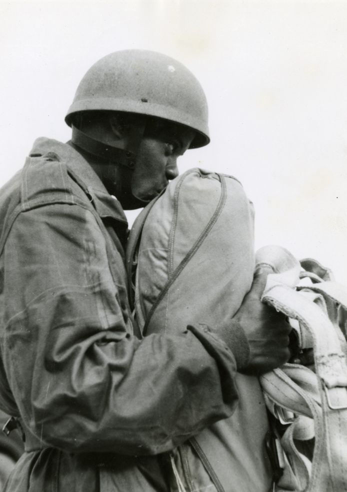 De Surinaamse militair Guillaume Kranenburg, parachutist bij de Prinses Irene Brigade, plakt bij wijze van traditie zijn kauwgom op de parachute om geluk te brengen.