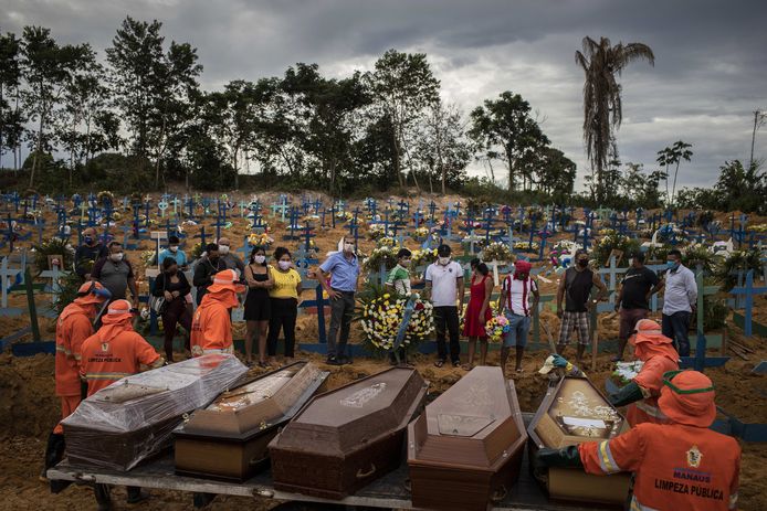 Inwoners van Manaus wonen een massabegrafenis bij.