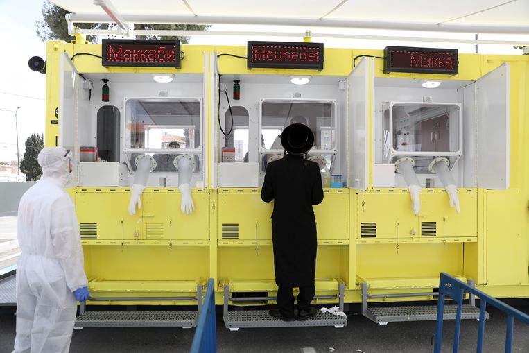 Een Joodse man wordt getest bij een mobiel teststation in Jeruzalem.  Beeld EPA