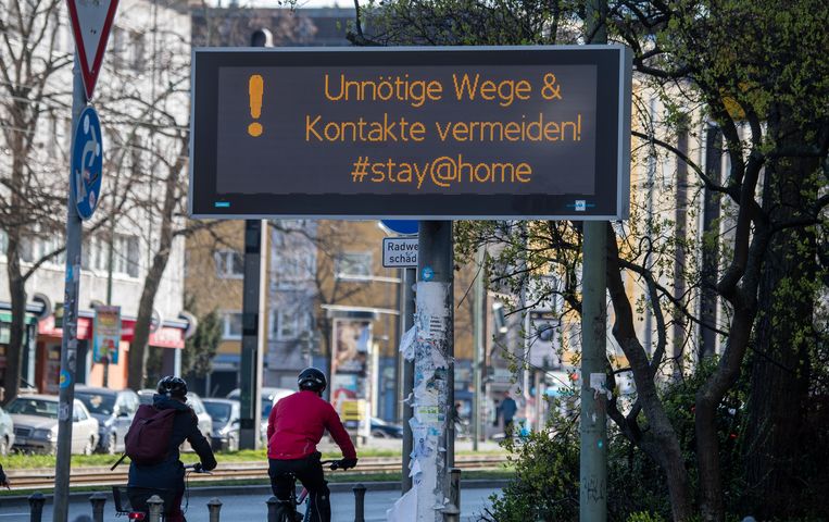 ‘Vermijd onnodige tripjes en contacten,’ staat op een bord in Berlijn. Beeld AFP