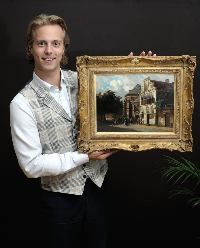 EDE - Kunsthandelaar Kas Buunk van Galerie Simonis en Buunk te Ede, 13 sep 2018 met een schilderij van een Woerdens stadsgezicht. Woerden, stadsgezicht, Buunk