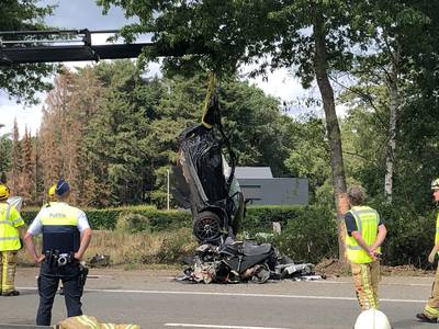 Porsche crasht tegen boom en breekt in twee stukken: één dode en een zwaargewonde