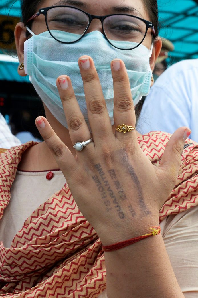 Une Indienne montre le tampon de quarantaine sur sa main.