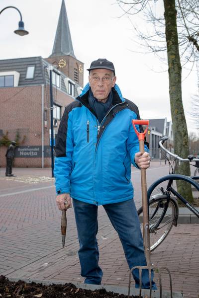 Adri stopt de bloembollen in de Dorpsstraat nog eens lekker in