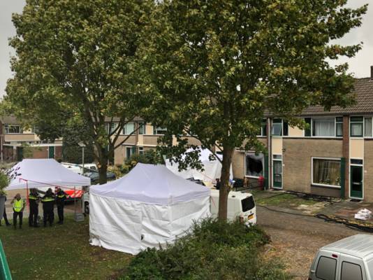 De politie doet in meerdere witte tenten onderzoek.