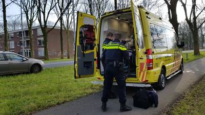 Gewonde fietser met fiets en al ingeladen in ambulance