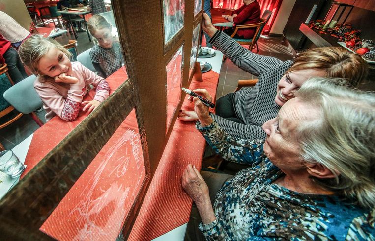 Jong en oud tekenden elkaars gezicht op een transparant doek.