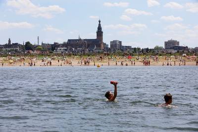 Verkoeling zoeken langs de Spiegelwaal op tropische zondag: ‘Verder dan tot onze knieën gaan we niet’