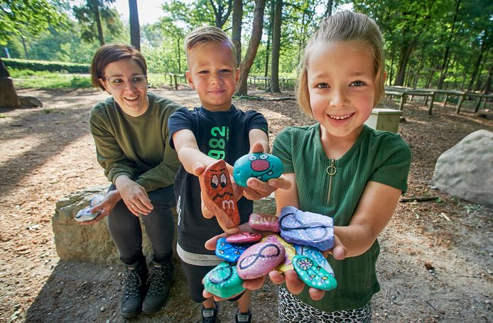 Loes Loocks Raaijmakers  en haar kinderen Rens en Fleur die zelfbeschilderde stenen in het bos neerleggen  zodat andere mensen ze vinden. Gisteren hebben ze de stenen op de foto in Herperduin neergelegd.