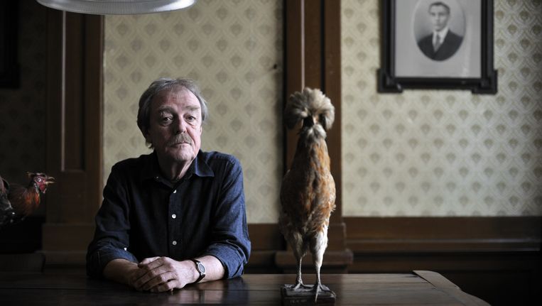 Middas Dekkers en een opgezette haan. Beeld Joost van den Broek