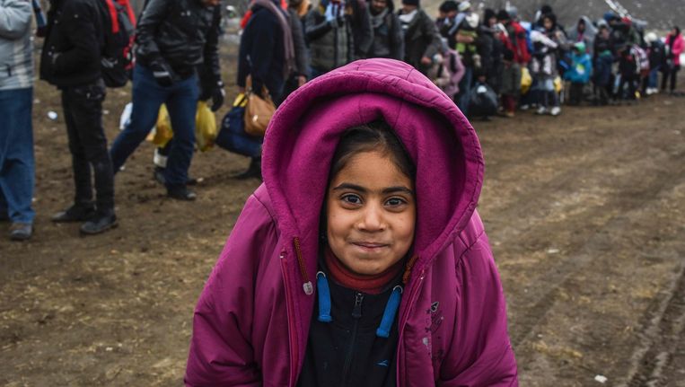 Een meisje poseert voor een foto terwijl ze wacht bij de grens tussen Macedonië en Servië. Beeld afp