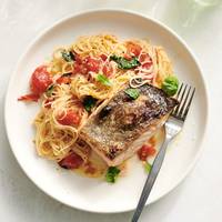 Minder dan een halfuurtje snel multitasken en je kan genieten van zalm met knoflookboter en tomatenpasta