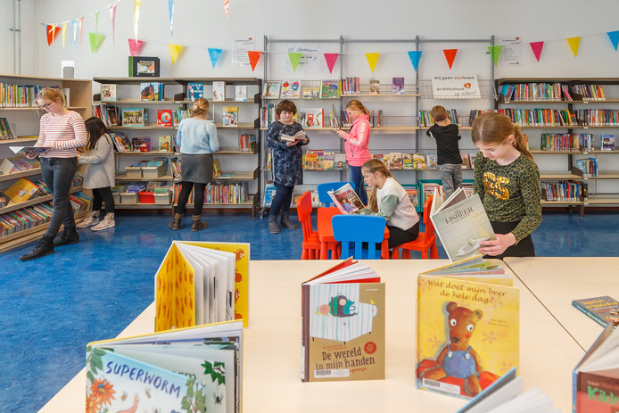 Leerlingen bekijken het boekenaanbod in de nieuwe schoolbibliotheek