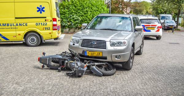 Motorrijder gewond bij aanrijding, motor klem onder auto.